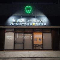 夜間発光する外照式サインと歯型ネオン管が印象的な歯科クリニックの外観施工事例｜兵庫県西宮市