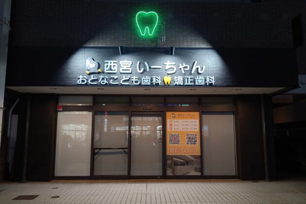 夜間発光する外照式サインと歯型ネオン管が印象的な歯科クリニックの外観施工事例｜兵庫県西宮市