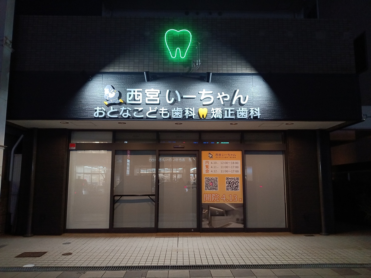 夜間発光する外照式サインと歯型ネオン管が印象的な歯科クリニックの外観施工事例｜兵庫県西宮市