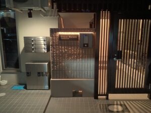集合郵便受けとオートロック設備を含む高級マンションエントランスサイン全景