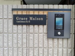真鍮切削文字と黒焼付塗装を組み合わせたマンション館銘板の昼間の仕上がり